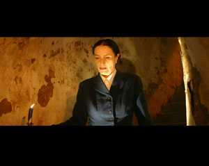 Ein Frau steht in einem Raum, nur mit Kerzenlicht beleuchtet ©Anna Porzelt