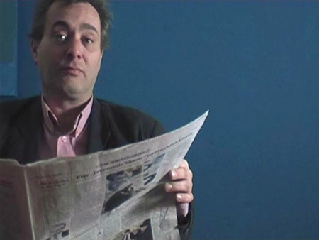 Mann vor blauer Wand blickt ber die Zeitung hinweg in Kamera ©N. Strehlow / P. Kaminiak