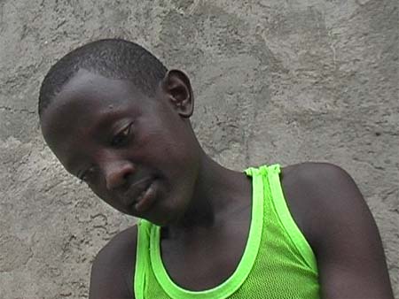 dunkelhutiger Junge vor afrikanischer Htte ©Johannes Hoffman